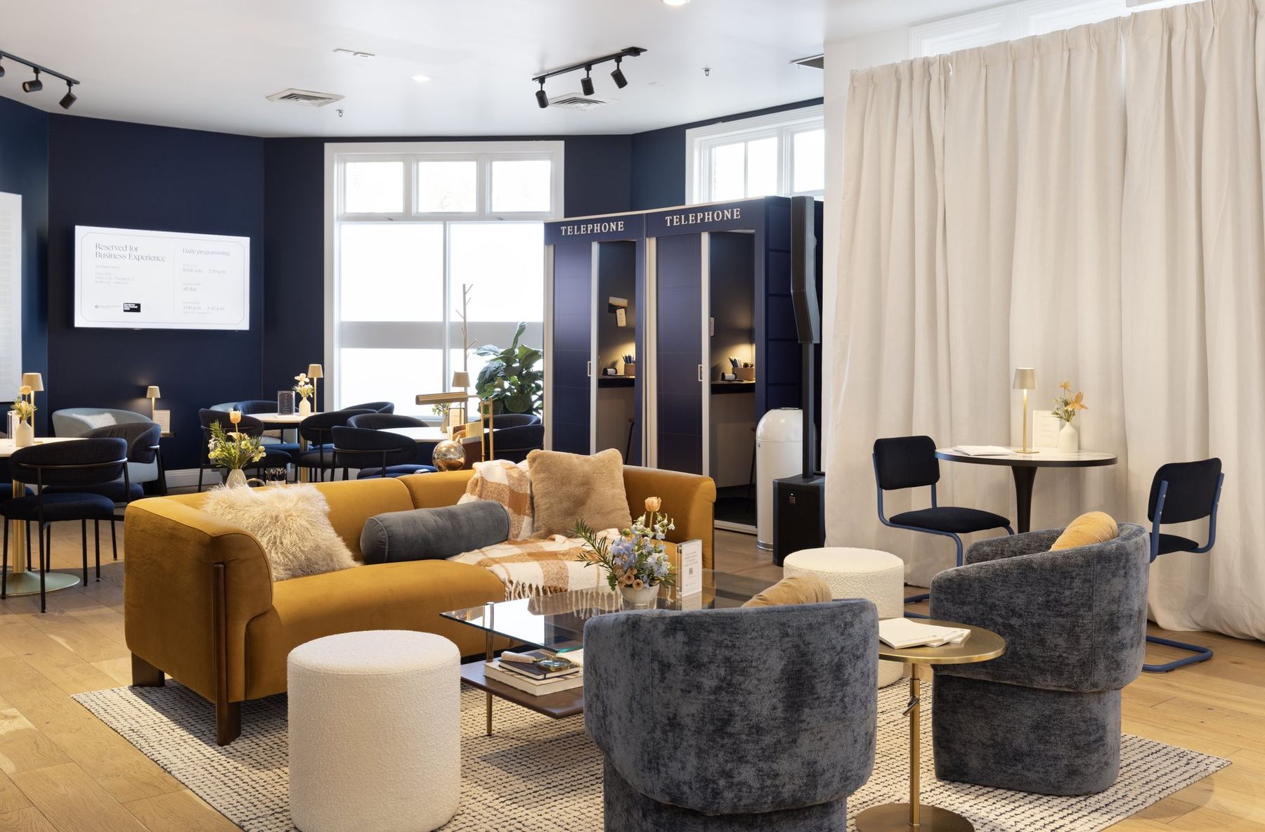 Chase for Business lounge seating with a mustard sofa, velvet chairs, and navy phone booths